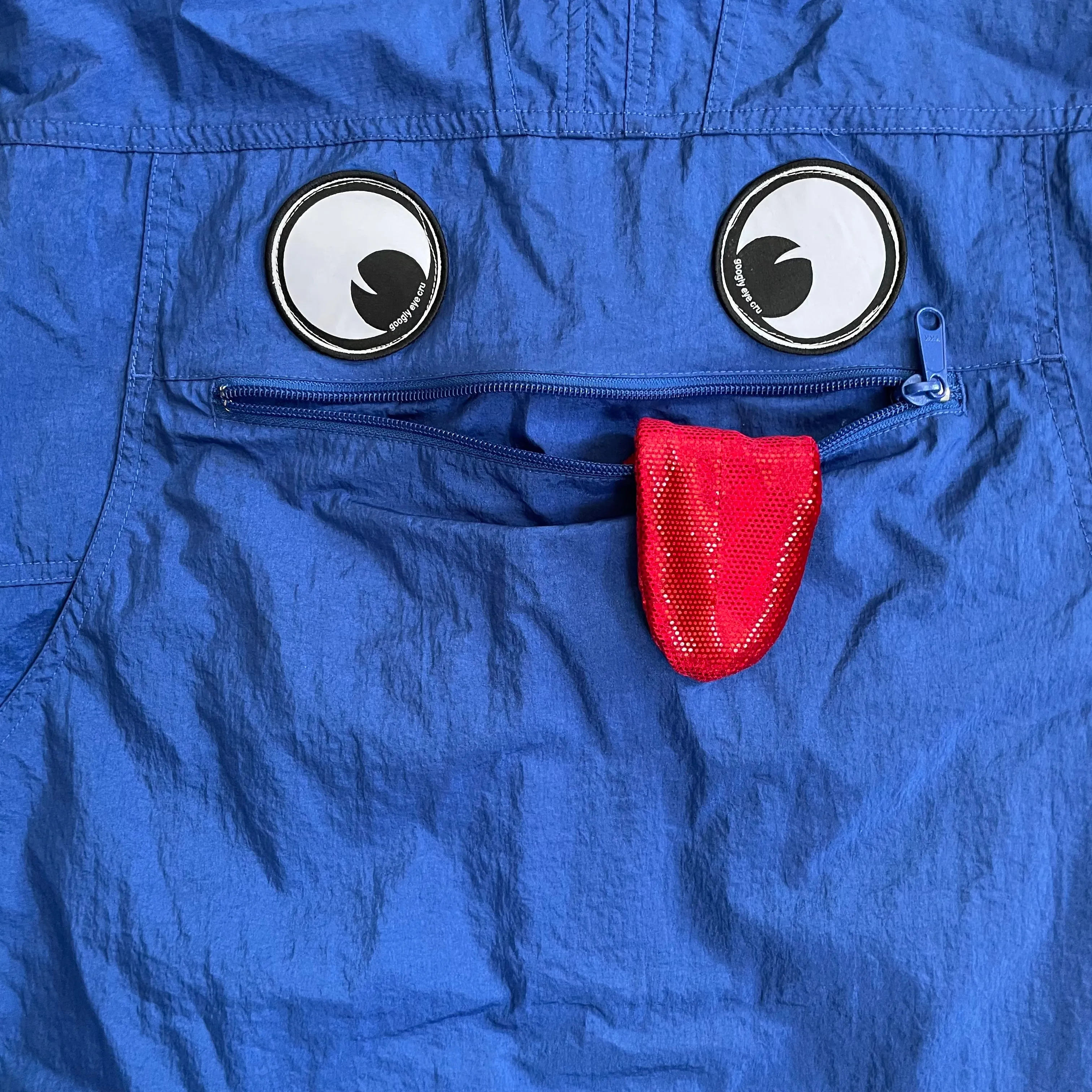 Upcycled hooded pullover windbreaker jacket with patches and tongue